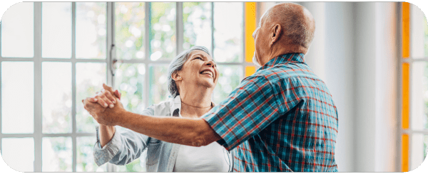 Two older people dancing and smiling together