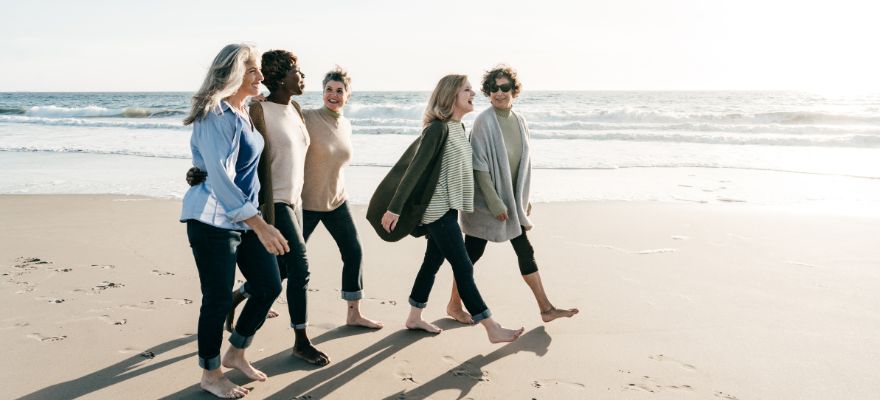 A group of females walking along the beach together