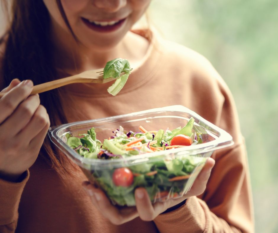 A young girl eating a healthy salad