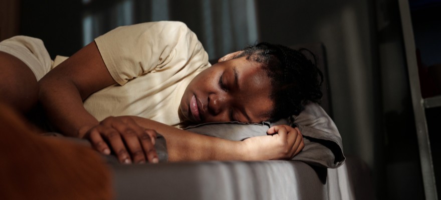 A young black woman laying on the sofa with her eyes closed